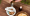 Close-up of herbal oil being poured into a bowl with Ayurvedic ingredients, symbolizing a traditional Ayurvedic detox ritual
