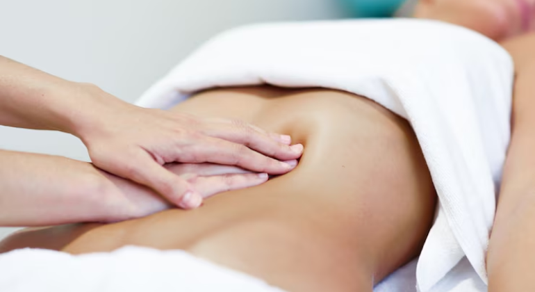 Person receiving a belly button massage with oil, a traditional Ayurvedic method to support digestion and detox