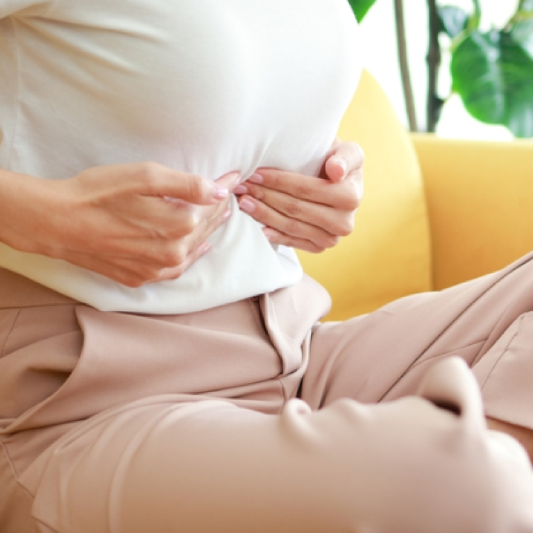 Female patient receiving abdominal massage for navel displacement, a condition that can indirectly affect reproductive health.