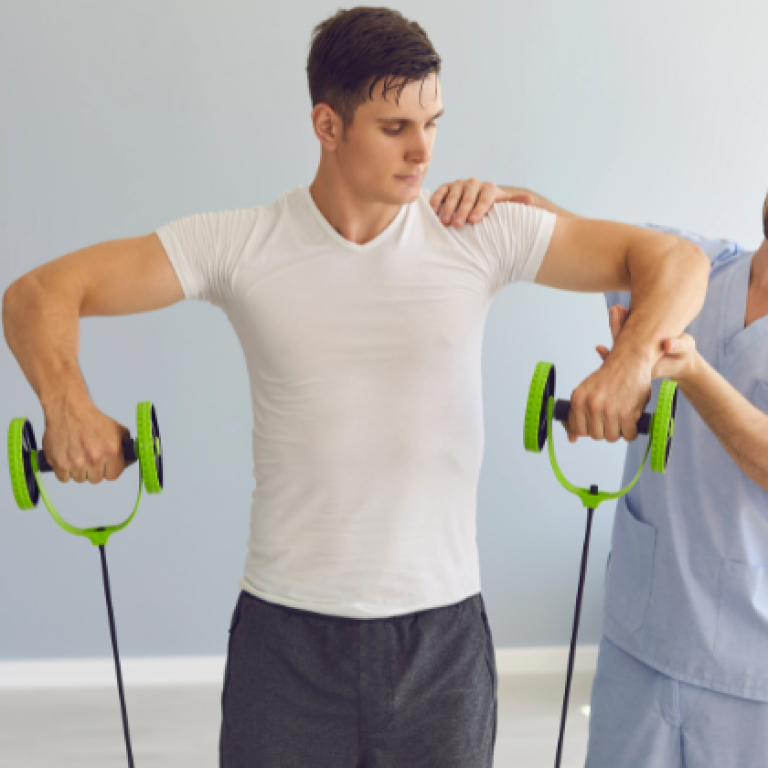 Physiotherapist guiding a male athlete through shoulder rehabilitation exercises using resistance bands during a sports injury recovery session.