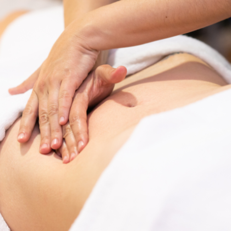 यह एक व्यक्ति के पेट की मालिश (abdominal massage) का चित्र है, जहां एक थेरेपिस्ट नाभि के आसपास हल्के दबाव के साथ उपचार कर रहा है। यह नाभि खिसकने (Naabhi Dislocation) को ठीक करने या पेट की मांसपेशियों को आराम देने के लिए की जाने वाली थेरेपी का हिस्सा हो सकता है।